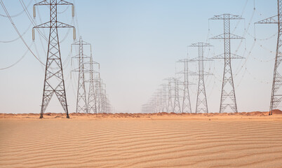 Power line transmission towers surround the Sahara in the desert in Egypt