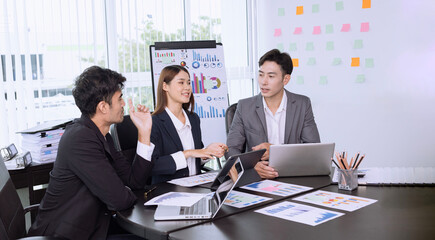 Team of Asian business people talking and planning working together in modern office.