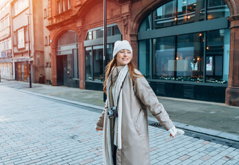 portrait of smiling young woman  having a fun time,  using phones  outdoor in a urban winter city. people, communication,  shopping and lifestyle concepts - obrazy, fototapety, plakaty