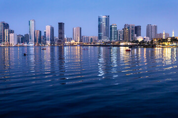 Fototapeta premium Beautiful view of Sharjah skyline in nighttime at Dubai creek. welcome in United Arab Emirates.