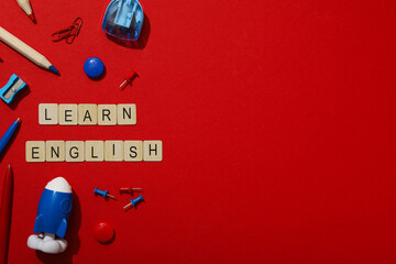 Concept of English lessons, flat lay, on red background. - obrazy, fototapety, plakaty