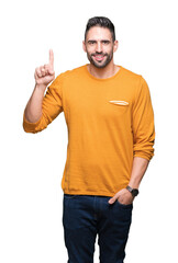 Naklejka premium Young handsome man over isolated background showing and pointing up with finger number one while smiling confident and happy.