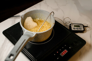 On the induction stove there is a ceramic pot in which the syrup is prepared