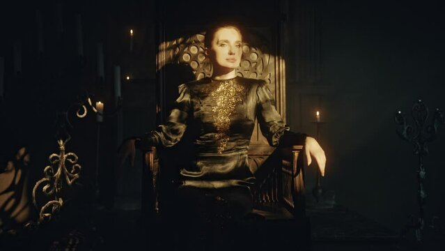 Portrait of a young woman in a black long dress sits in a wooden carved throne in a dark Gothic church. Looks at the camera. Meditation and expression. Fashion and Cinematic concept