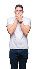 Young man wearing casual white t-shirt over isolated background shocked covering mouth with hands for mistake. Secret concept.