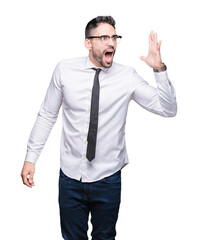 Young handsome business man wearing glasses over isolated background shouting and screaming loud to side with hand on mouth. Communication concept.