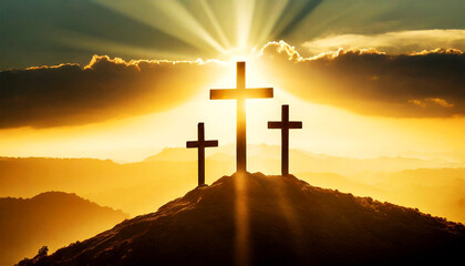 Silhouette of three wooden religious crosses above the hill against a dramatic sky and sunbeams at sunset or sunrise. Religious symbol of good Friday.