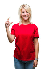 Young beautiful blonde woman wearing red t-shirt over isolated background smiling and confident gesturing with hand doing size sign with fingers while looking and the camera. Measure concept.
