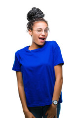 Young braided hair african american girl wearing glasses over isolated background winking looking at the camera with sexy expression, cheerful and happy face.