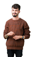 Young handsome man wearing winter sweater over isolated background winking looking at the camera...