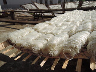 traditional way of rice noodles production in South East Asia, VIetnam,hand made noodles from rice flour are than drying outside on street on the sun on bamboo constructions,tasty delicious local food