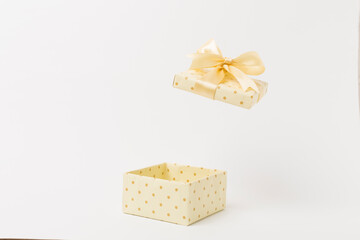Beige open gift box on color background