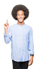 Young african american man with afro hair showing and pointing up with finger number one while smiling confident and happy.