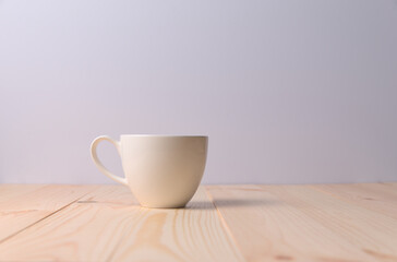 Hot drinks in a white cup on wooden table with white background.