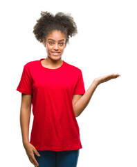 Young afro american woman over isolated background smiling cheerful presenting and pointing with...