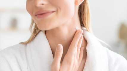 Cropped of lady pampering neck skin with moisturizer in bathroom - obrazy, fototapety, plakaty