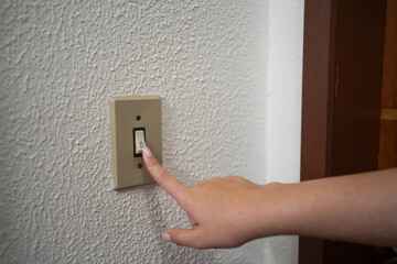 Close-up of a girl's hands ringing a house doorbell.