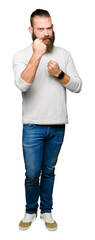 Young blond man wearing casual sweater Ready to fight with fist defense gesture, angry and upset face, afraid of problem