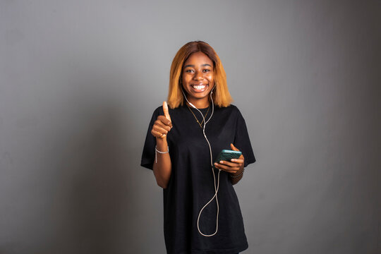 happy young black woman listening to music from her phone