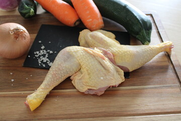 Cuisses de poulet, viande crue, sur la table en bois de la cuisine