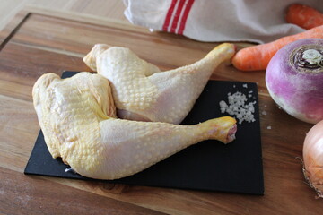 Cuisses de poulet, viande crue, sur la table en bois de la cuisine