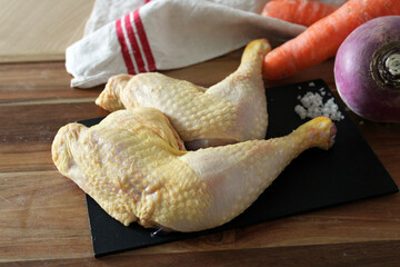 Cuisses de poulet, viande crue, sur la table en bois de la cuisine