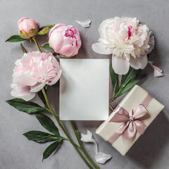 Blank greeting card with pastel pink peony flowers and gift box on gray background. Wedding invitation. Mock up. Flat lay. Womans day, Valentines day layout