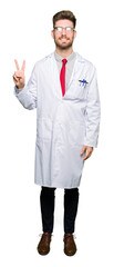 Fototapeta premium Young handsome scientist man wearing glasses showing and pointing up with fingers number two while smiling confident and happy.
