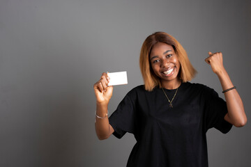 Young African woman pointing at her Blank Credit Card