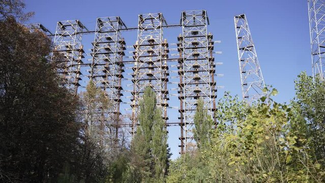 Zoom in though trees of Duga radar system in abandoned military base in Chernobyl Exclusion Zone, Ukraine. High quality 4k footage
