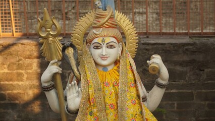 closeup shot of sculpture of lord shiva wearing yellow cloth in temple