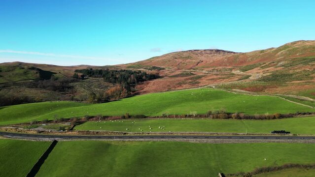 Aerial footage panning alongside A6 road near Kendal in the Lake District, UK