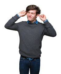 Fototapeta premium Young handsome elegant man over isolated background Smiling pulling ears with fingers, funny gesture. Audition problem
