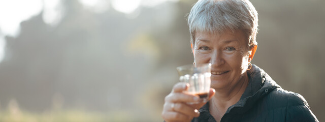Healthy grandmother with shot grey hair is drinking and enjoying coffee time in the morning with joyful, smile, inspiration, motivation and happy emotion. A portrait of female elderly with copy space.