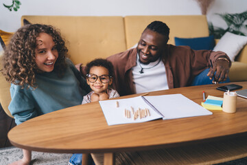 Cheerful multiethnic family spending joyful moment together in living room