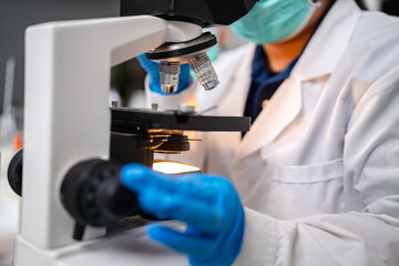 Scientists using microscope to recording ecological, examining and sample of experiment in night laboratory, genetic and chemistry research, discovery of new medicine, develop and analyzing futuristic