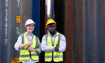 Portrait of two workers standing with thumbs up in front of container