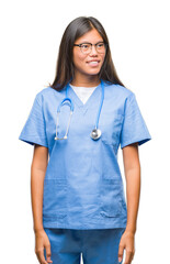 Young asian doctor woman over isolated background looking away to side with smile on face, natural expression. Laughing confident.