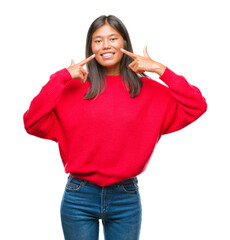 Young asian woman wearing winter sweater over isolated background smiling confident showing and pointing with fingers teeth and mouth. Health concept.