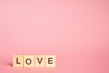 The word love made up of individual letters on a pink background with copy space. Valentine's Day concept