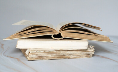 Pile de livres anciens avec un livre ouvert sur le dessus - vieux livres empilés avec un livre ouvert devant un fond clair