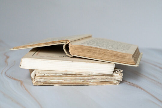 Pile de livres anciens avec un livre ouvert sur le dessus - vieux livres empilés avec un livre ouvert devant un fond clair