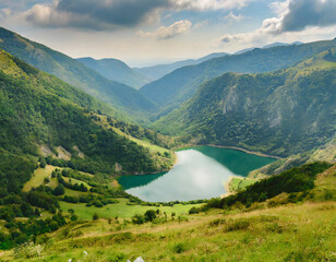 Fototapeta na wymiar nature scene with lake in valley surrounded by green mountains