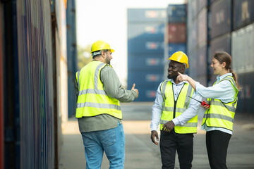 Group of workers in a container storage yard greeting each other during breaks in front of container warehouse,