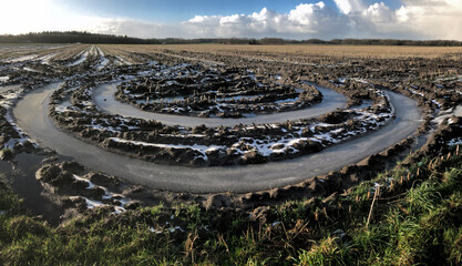 Fototapeta na wymiar Winter at the es of Uffelte Drenthe Netherlands. Fields with frozen water. Ice. Circles in the muddy field. Panorama. Country life. Circles in the landscape. Mud tracks.