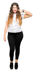Young beautiful woman wearing casual white t-shirt Pointing with hand finger to face and nose, smiling cheerful