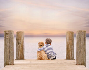 süßer kleiner Junge mit Hund am Meer