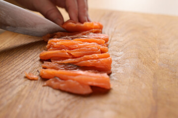 Cut the salmon into pieces with a knife. Cooking dishes from red fish
