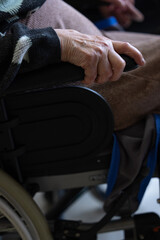 gros plan sur les mains d'une personne âgée assise dans un fauteuil roulant