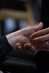 une femme tient les mains d'une personne âgée. Symbole de solidarité intergénérationnelle
